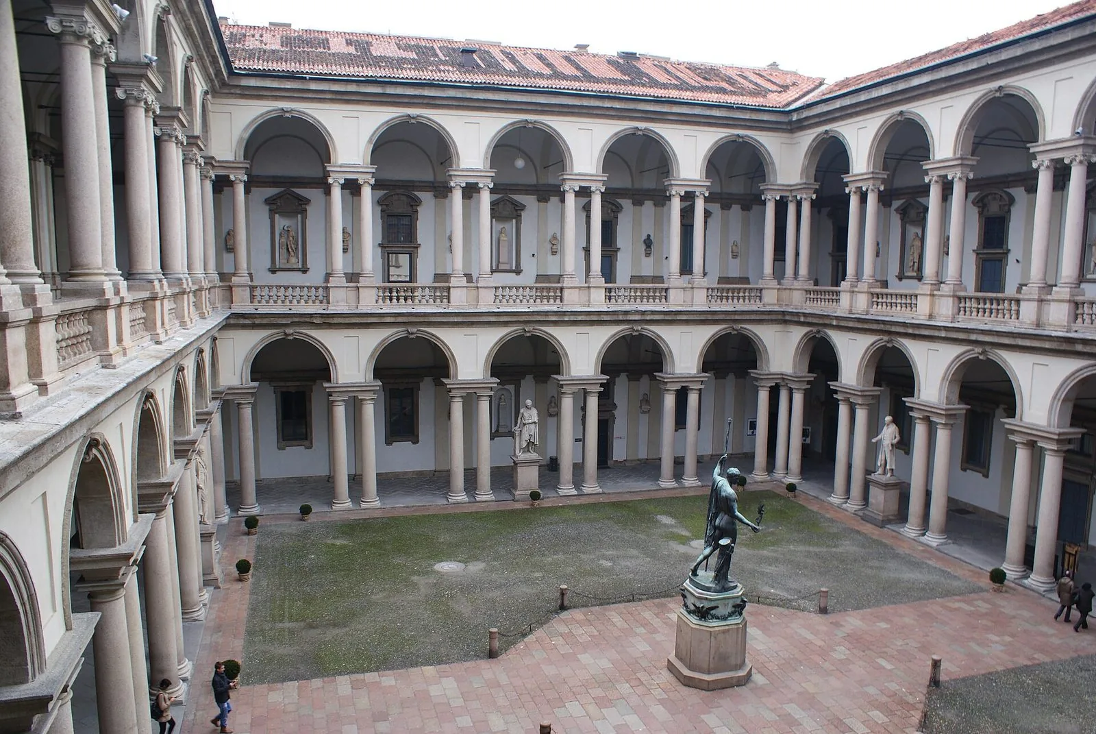 Cortile d'onore di Palazzo Brera a Milano con il doppio loggiato ad archi e la statua di Napoleone al centro
