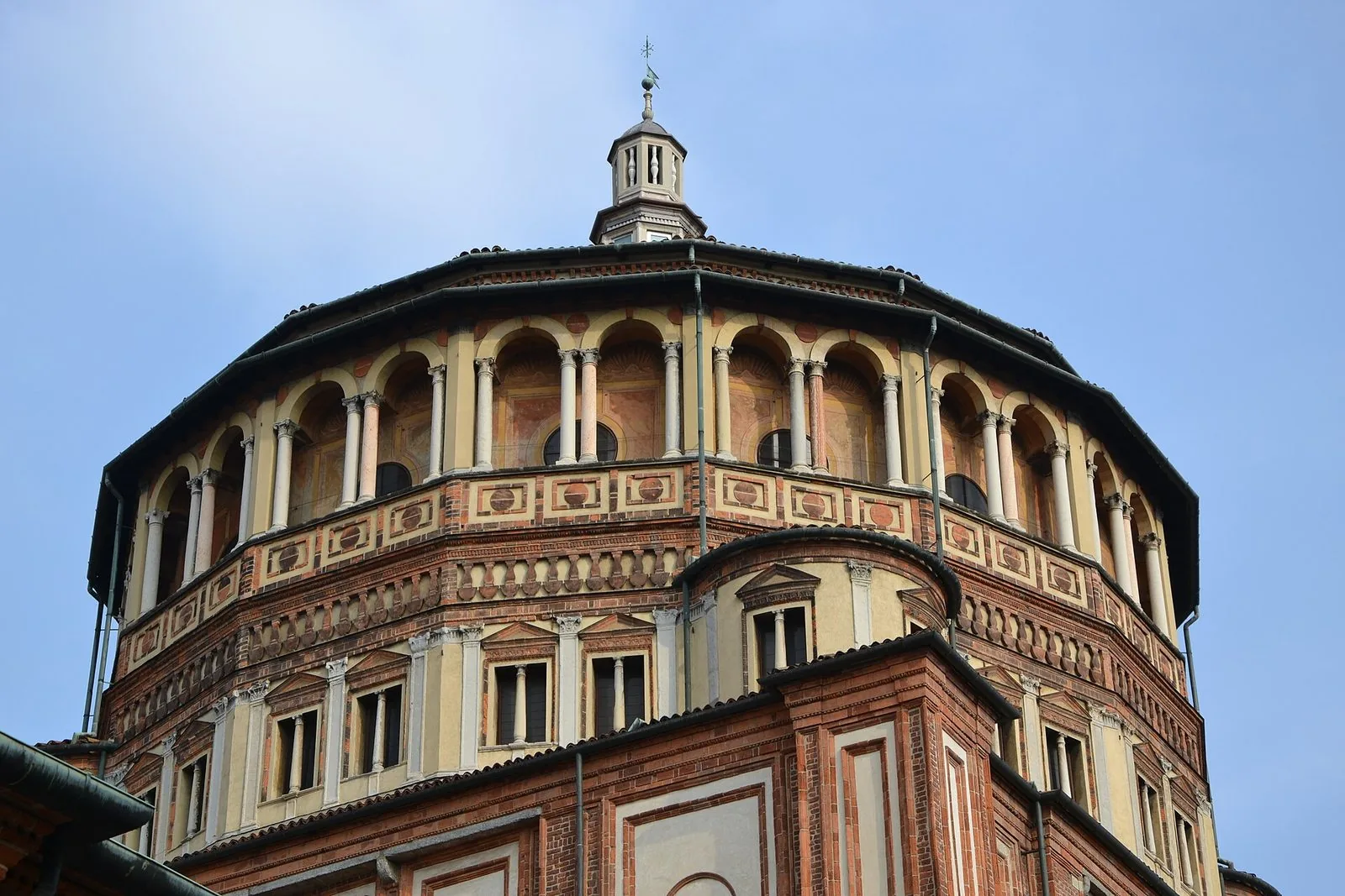 Tiburio rinascimentale in cotto e intonaco della chiesa di Santa Maria delle Grazie a Milano contro il cielo azzurro